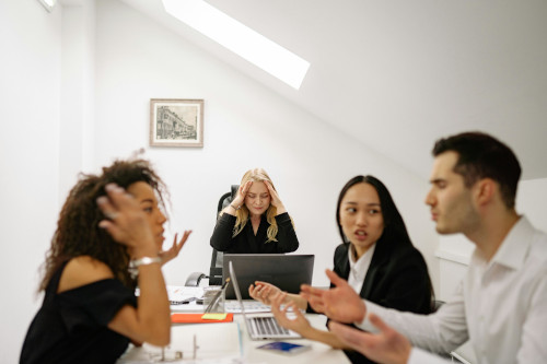 A team seated at a desk arguing about an ongoing email scandal